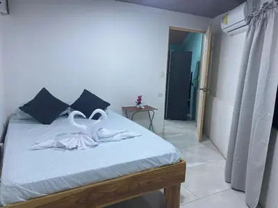 a bedroom with two swans towels on a bed at Casa DiTi 3 in Paraíso