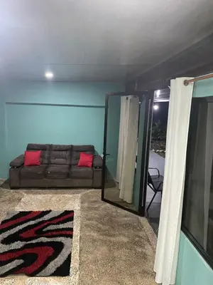 a living room with a couch and a mirror at Casa DiTi 3 in Paraíso