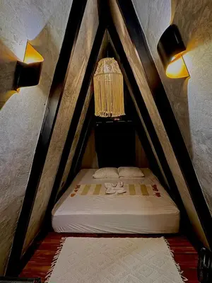 a small bed with a bird cage in a room at Chalet de los ciervos in Isla Cabuya