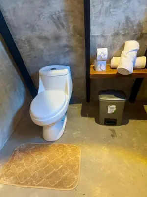 a bathroom with a toilet and a shelf with towels at Chalet de los ciervos in Isla Cabuya
