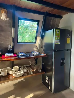 a kitchen with a stainless steel refrigerator and a window at Chalet de los ciervos in Isla Cabuya