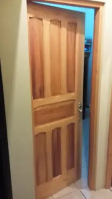 a wooden door in a room with a bathroom at Morada Kampos in Heredia