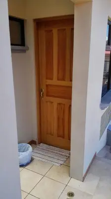a room with a wooden door and a tile floor at Morada Kampos in Heredia