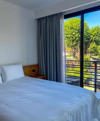 a bedroom with a bed and a large window at Casa Swell Boutique Hotel Santa Teresa in Santa Teresa Beach