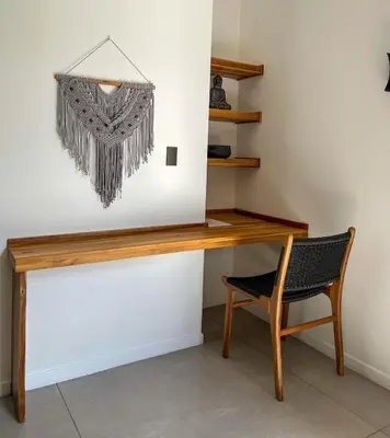 a wooden desk with a chair next to a wall at Casa Swell Boutique Hotel Santa Teresa in Santa Teresa Beach
