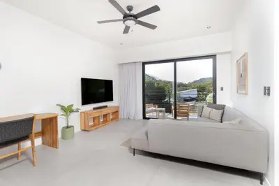 a living room with a couch and a flat screen tv at Casa Swell Boutique Hotel Santa Teresa in Santa Teresa Beach