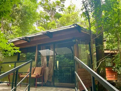 a small cabin with a porch in the woods at Cabañas La Montaña in Monteverde Costa Rica