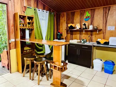 a kitchen with a wooden table and stools in it at Cabañas La Montaña in Monteverde Costa Rica