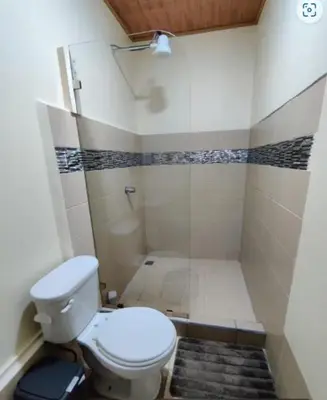 a small bathroom with a toilet and a shower at Vista Lapas Cottage in Guayabal