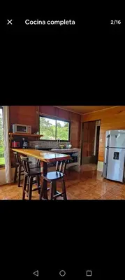 a kitchen with a table and chairs and a refrigerator at Vista Lapas Cottage in Guayabal