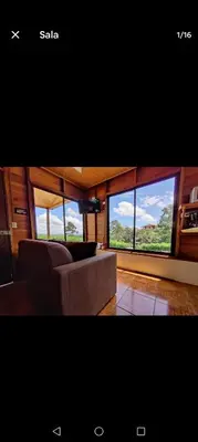 a living room with a couch and large windows at Vista Lapas Cottage in Guayabal