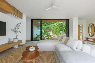 a living room with a white couch and a table at Villa Koa - Your Tropical Retreat in Santa Teresa Beach