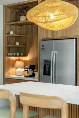 a kitchen with a stainless steel refrigerator and a chandelier at Villa Koa - Your Tropical Retreat in Santa Teresa Beach