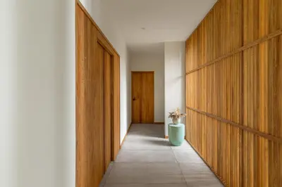 a hallway with wooden doors and a plant in a vase at Villa Koa - Your Tropical Retreat in Santa Teresa Beach