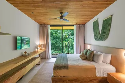 a bedroom with a bed and a large window at Villa Koa - Your Tropical Retreat in Santa Teresa Beach