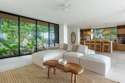 a living room with a white couch and a table at Villa Koa - Your Tropical Retreat in Santa Teresa Beach