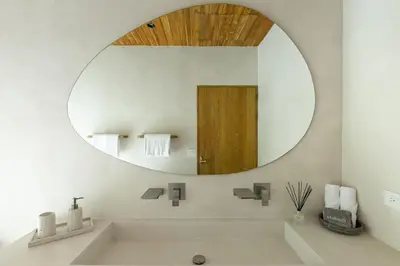 a bathroom with a large mirror and a sink at Villa Koa - Your Tropical Retreat in Santa Teresa Beach