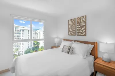 a bedroom with a white bed and a large window at Upstay - Brand New Condo w Pool - Near the Beach in Jacó