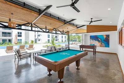 a pool table in the middle of a room at Upstay - Brand New Condo w Pool - Near the Beach in Jacó