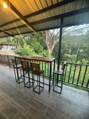 a porch with chairs and a table on a balcony at Villa Colibrí a solo 5mins de Playa Carrillo in Hojancha