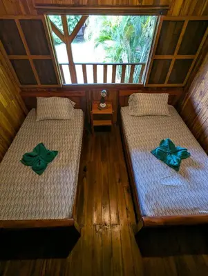two beds with green bows on them in a room at Casa Escondida 10min from Carrillo beach in Arbolito