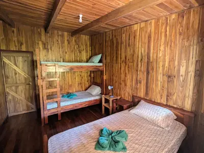 a bedroom with two bunk beds in a wooden cabin at Casa Escondida 10min from Carrillo beach in Arbolito