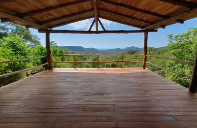 a wooden boardwalk with a view of the mountains at Casa Escondida 10min from Carrillo beach in Arbolito