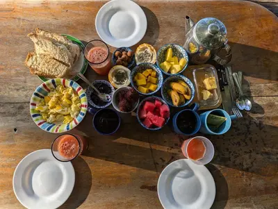 a table topped with plates and bowls of food at Casa Escondida 10min from Carrillo beach in Arbolito