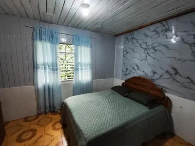 a bedroom with a bed and a window at Casa de campo Aguinaldo in Fortuna
