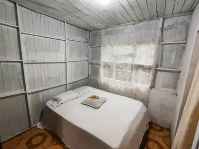a small room with a bed and two windows at Casa de campo Aguinaldo in Fortuna