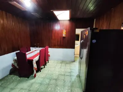 a dining room with a table and chairs and a refrigerator at Casa de campo Aguinaldo in Fortuna