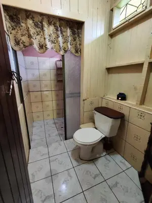 a small bathroom with a toilet and a window at Casa de campo Aguinaldo in Fortuna