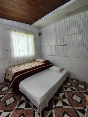 a bedroom with two beds in a room with white walls at Casa de campo Aguinaldo in Fortuna