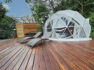 a wooden deck with two chairs and an igloo at Moonlight glamping in Fortuna