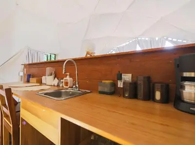 a kitchen counter with a sink and a coffee maker at Moonlight glamping in Fortuna