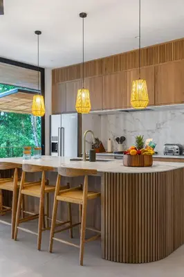 a kitchen with wooden cabinets and a large wooden table at Casa Roca in Santa Teresa Beach