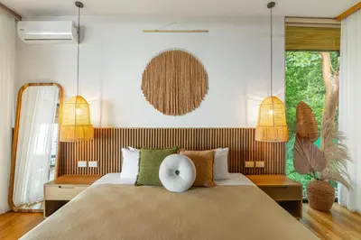 a bedroom with a large bed and two lamps at Casa Roca in Santa Teresa Beach