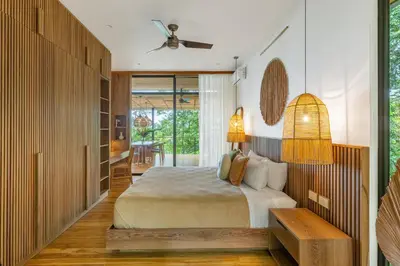 a bedroom with a bed and a ceiling fan at Casa Roca in Santa Teresa Beach
