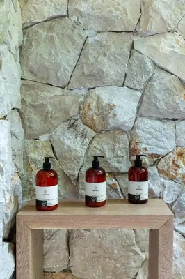 two jars on a wooden shelf in front of a stone wall at Casa Roca in Santa Teresa Beach
