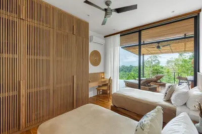 a bedroom with two beds and a large window at Casa Roca in Santa Teresa Beach