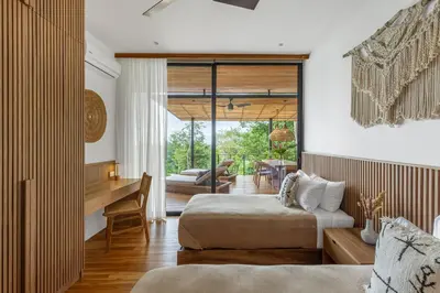 a bedroom with two beds and a desk in a room at Casa Roca in Santa Teresa Beach