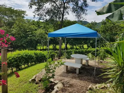 a blue tent and a bench in a garden at Cabana Luna in Jicaral