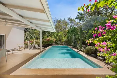a swimming pool in a backyard with flowers at 3-BD Home with Pool Near Beach in Brasilito