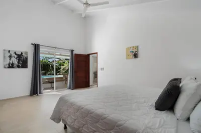 a white bedroom with a bed and a sliding glass door at 3-BD Home with Pool Near Beach in Brasilito