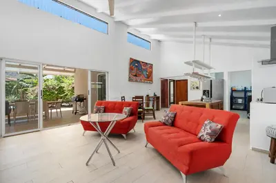 a living room with two red chairs and a table at 3-BD Home with Pool Near Beach in Brasilito