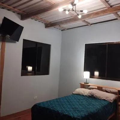a bedroom with a bed and a flat screen tv at Nidos Paradise's in Buenos Aires