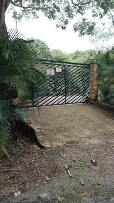 a wooden fence with a gate and a brick pillar at Nidos Paradise's in Buenos Aires