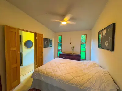 a bedroom with a bed and a window at Quintaesencia Arte y Naturaleza in Guápiles