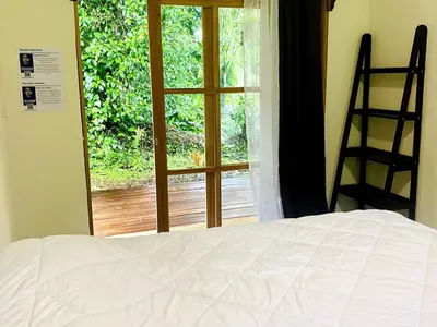 a bedroom with a bed and a view of a window at Quintaesencia Arte y Naturaleza in Guápiles