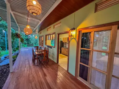 a dining room and kitchen with a table and chairs at Quintaesencia Arte y Naturaleza in Guápiles